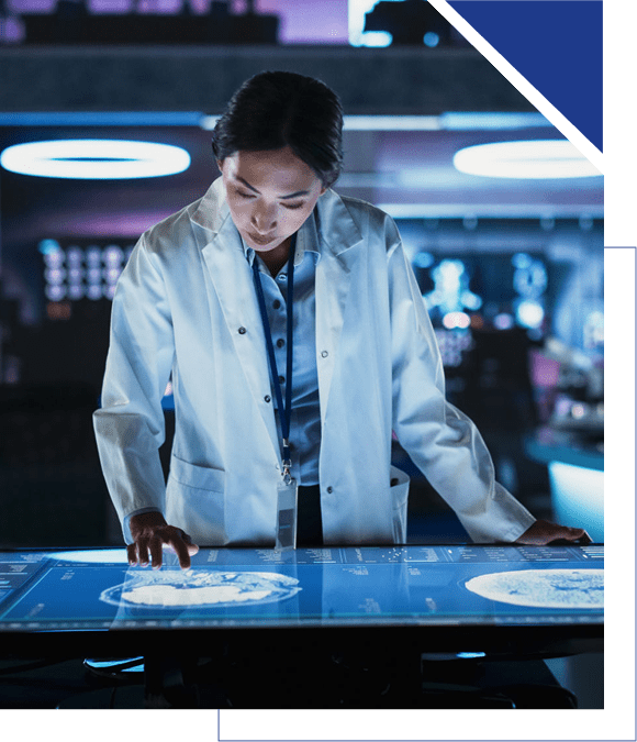 Scientist examining data on a digital touchscreen table in a lab.